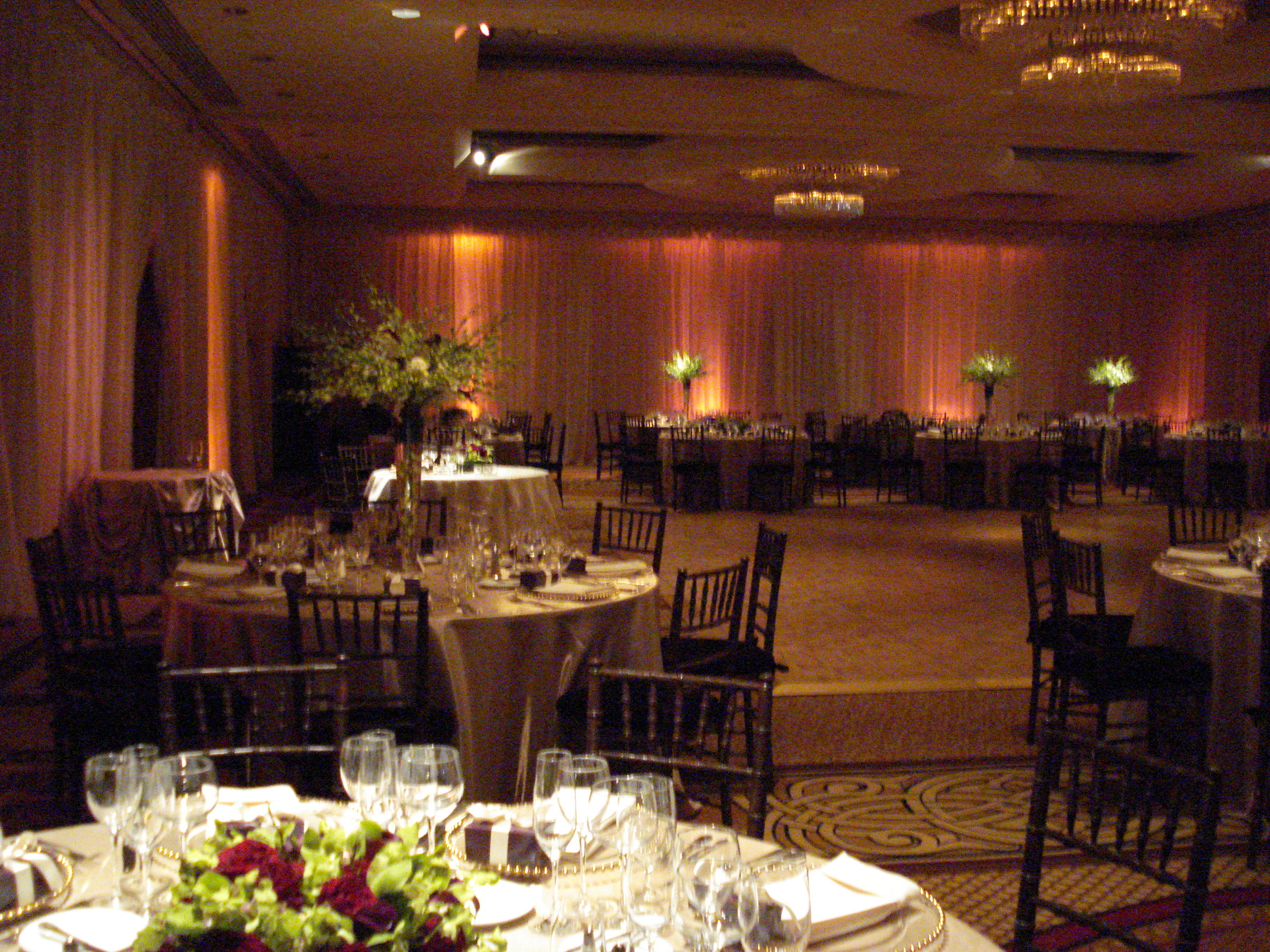 Park Hyatt ballroom with billowy fabric walls, washed with a soft amber up lights around the room and the pinspots highlighting the centerpieces
